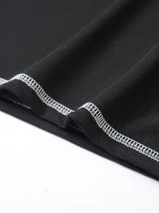 Close-up of waffle knit texture and white contrast stitching on black Henley shirt