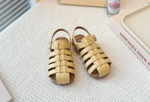 Close-up detail of yellow hollow-out woven Roman sandals with soft soles for children