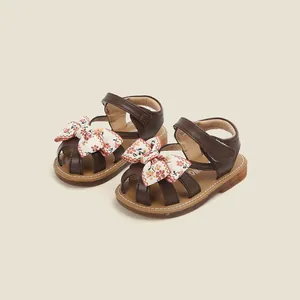 Brown toddler girl summer sandals featuring a floral bow and soft protective toe
