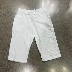 Detail view of white linen-textured men's drawstring cropped pants for casual summer wear