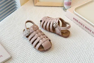 A detailed view showing the pink woven Roman sandals for children with a closed-toe design