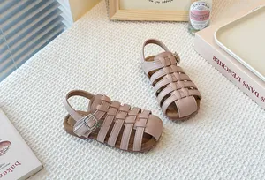Close-up detail showing the woven hollow design of pink girl's Roman summer sandals