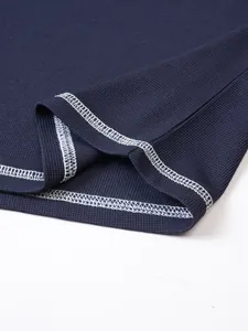 Detailed macro shot showing the navy waffle knit Henley shirt hem with white contrast stitching.