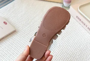 High-quality detailed view of non-slip rubber sole on girls woven Roman sandals
