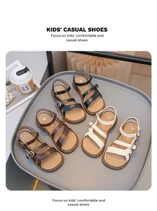 A collection of stylish girls' summer sandals in black, brown, and white displayed on a tray