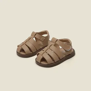 Vue détaillée de sandales en cuir marron pour tout-petits avec bout fermé et velcro.