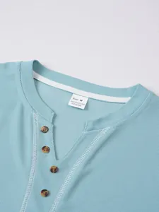 Detail view of a blue waffle knit Henley shirt collar with buttons and size label