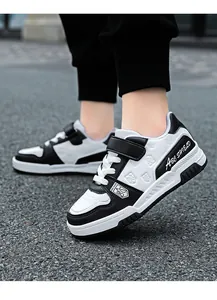 Detailed view of kids' black and white leather sneakers with Velcro strap
