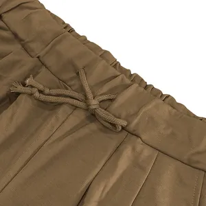 Close-up detail of elastic waistband and adjustable drawstring on brown sports shorts