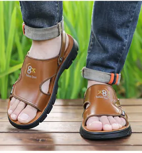 Close-up view of model wearing brown leather men's sandals on a rustic wooden deck outdoors