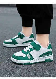 Close-up of green and white kids sneakers with velcro strap and leather surface