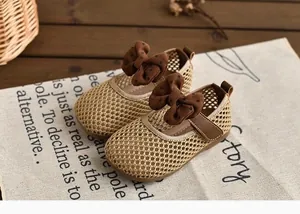 Détail de chaussures en maille pour petites filles avec nœuds marrons à pois