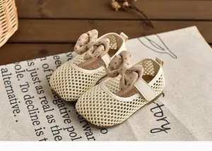 Vue détaillée des sandales en maille crème pour bébé fille avec un joli nœud à pois