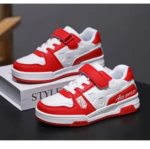 Detailed view of red and white kids' sneakers with hook-and-loop straps and shield logo
