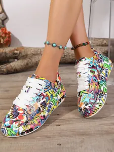 Women's colorful graffiti print sneakers with white laces and thick soles on wooden floor.