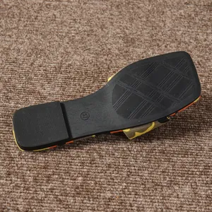 Detailed close-up view of the non-slip black rubber sole on a camouflage flat sandal.