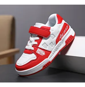 Detailed side view of a red and white children's leather sneaker with Velcro strap