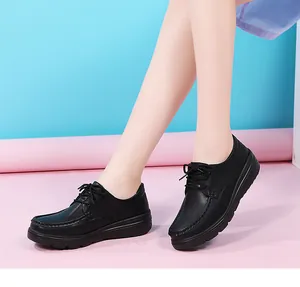 Detailed view of black lace-up nursing shoes with non-slip thick soles on an Asian model.