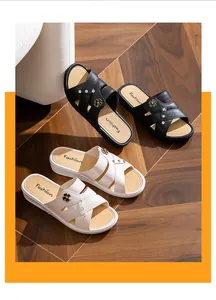 Gros plan détaillé de mules compensées noires et beige avec fleurs et brillants strass
