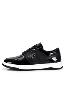 Detailed side view of black patent leather men's low-top sneakers with white sole