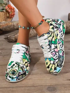 Close-up of women's colorful graffiti print sneakers with white laces on wooden floor.