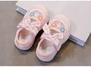Vista detallada de sandalias rosas para niñas con diseño de malla y flores bordadas.
