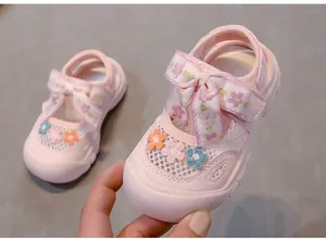 Primer plano de sandalias rosas para niñas con flores bordadas y malla