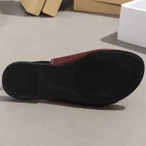 Close-up detail of the anti-slip black sole on a women's flat summer beach sandal.