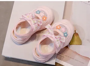 Detalle de sandalias de princesa de malla rosa con flores para niñas pequeñas