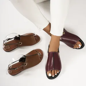 Detail view of flat open-toe beach sandals in brown and burgundy on white background
