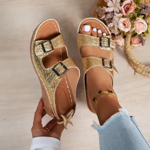 Close-up of golden crocodile texture wedge sandals featuring double black buckles and platform