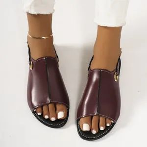 Detailed view of stylish burgundy flat open-toe sandals with metal eyelet accents.