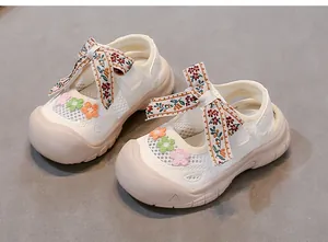 Vista detallada de sandalias de malla crema para bebé niña con lazos de flores