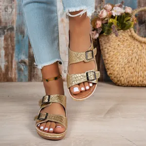 Detail view of gold wedge sandals featuring faux crocodile texture and double buckle straps