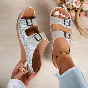 Silver crocodile-textured platform sandals with double buckles, shown in a detailed wear view.
