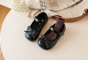 Detail view of black girls' Mary Jane princess shoes with elegant bows and leather texture