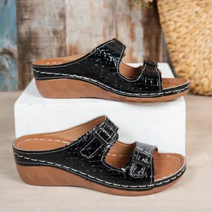 Close-up detail view of stylish black crocodile pattern wedge sandals with double metal buckles.
