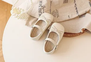 Detailed top view of elegant off-white girls Mary Jane shoes with a bow detail
