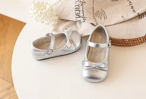 Detailed view of silver girls' Mary Jane shoes with cute bow and buckle strap.
