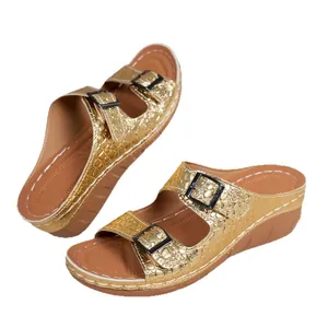 Gold platform wedge sandals with crocodile pattern and double buckle straps.