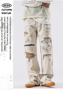 Détail d'un jean baggy blanc cassé de style américain avec de fortes déchirures.