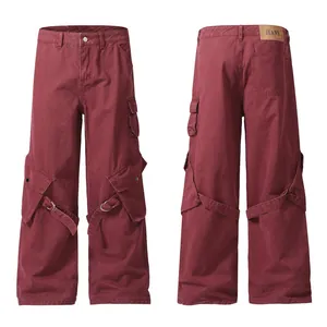 Detailed view of burgundy wide-leg cargo pants featuring unique strap and large pockets.