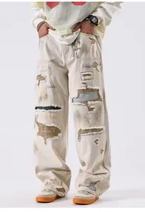 Détail de jean baggy blanc cassé avec déchirures et accents de couleurs contrastées