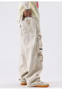 Détail d'un jean baggy beige délavé avec taches de peinture style bûcheron américain