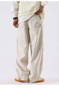 Vue arrière d'un jean baggy homme blanc cassé avec détails usés et taches de peinture