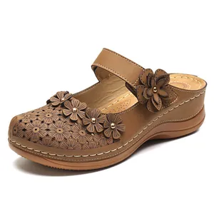 Vintage brown women's wedge sandals with floral appliqués and laser-cut flower patterns.