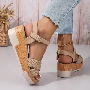 Vista detallada de sandalias de cuña beige con correa trenzada y hebilla ajustable
