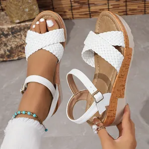 Primer plano de sandalias blancas de cuña con plataforma trenzada y correa al tobillo