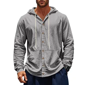 Gros plan sur la texture d'une chemise à capuche en lin gris avec boutons et poche.