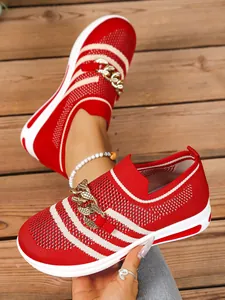 Close-up of red and white striped mesh sneakers with decorative gold chain and white sole